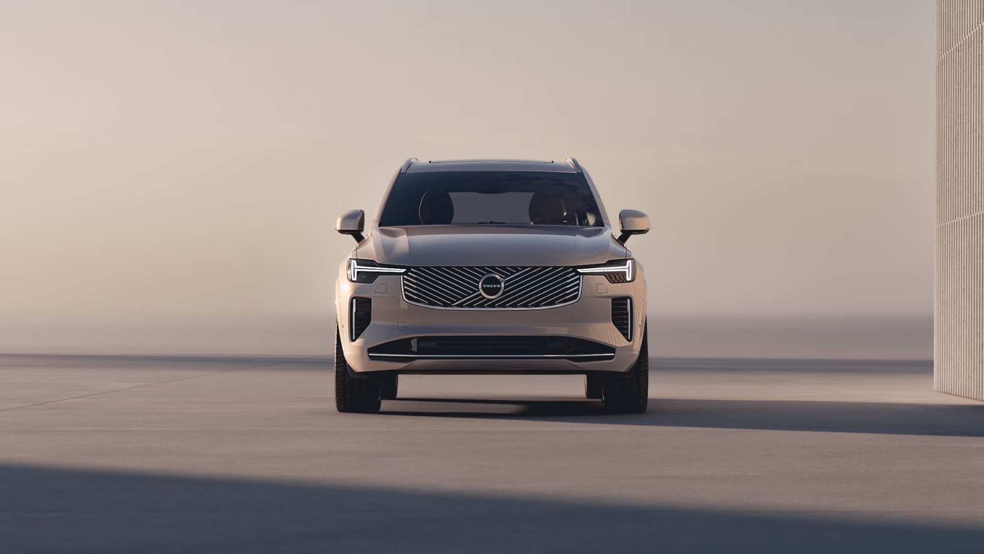 Volvo XC90 2025 garé dans un décor minimaliste, VUS de luxe à 3 rangées.